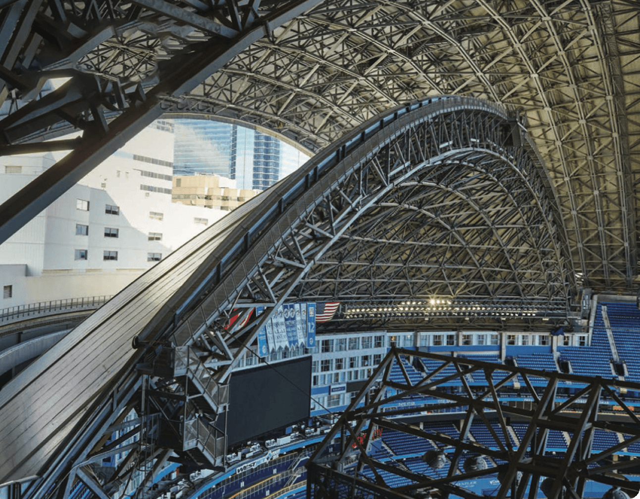 Rogers Centre interior showing curved retractable roof, structural steel trusses, motorized panels and blue seating bowls