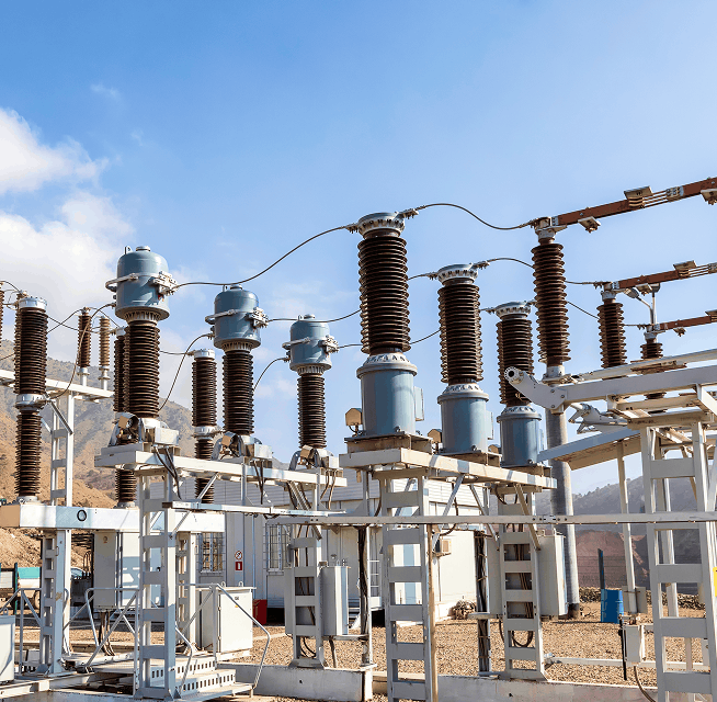 Outdoor high-voltage substation with ceramic insulators, switchgear and steel support structures at a mining site