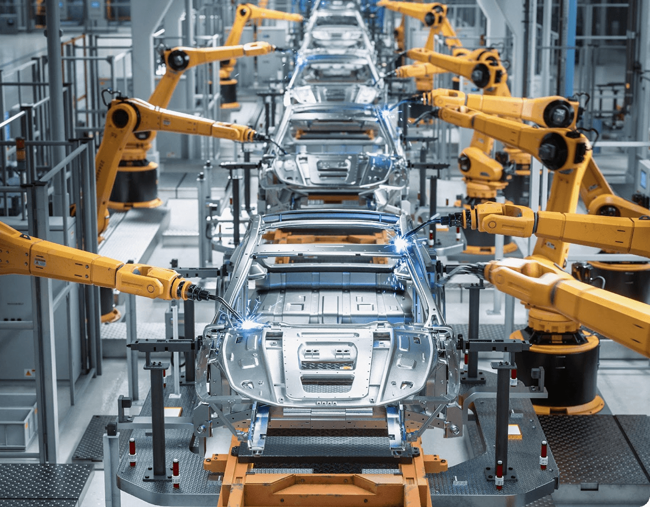 Multiple robotic welding arms assembling EV body shells along an automated automotive production line in a factory